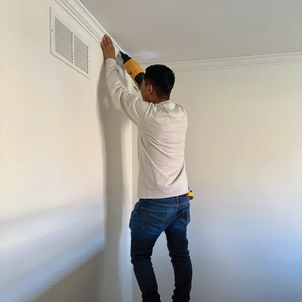 Residential home's interior full repaint and crew member installing crown molding.