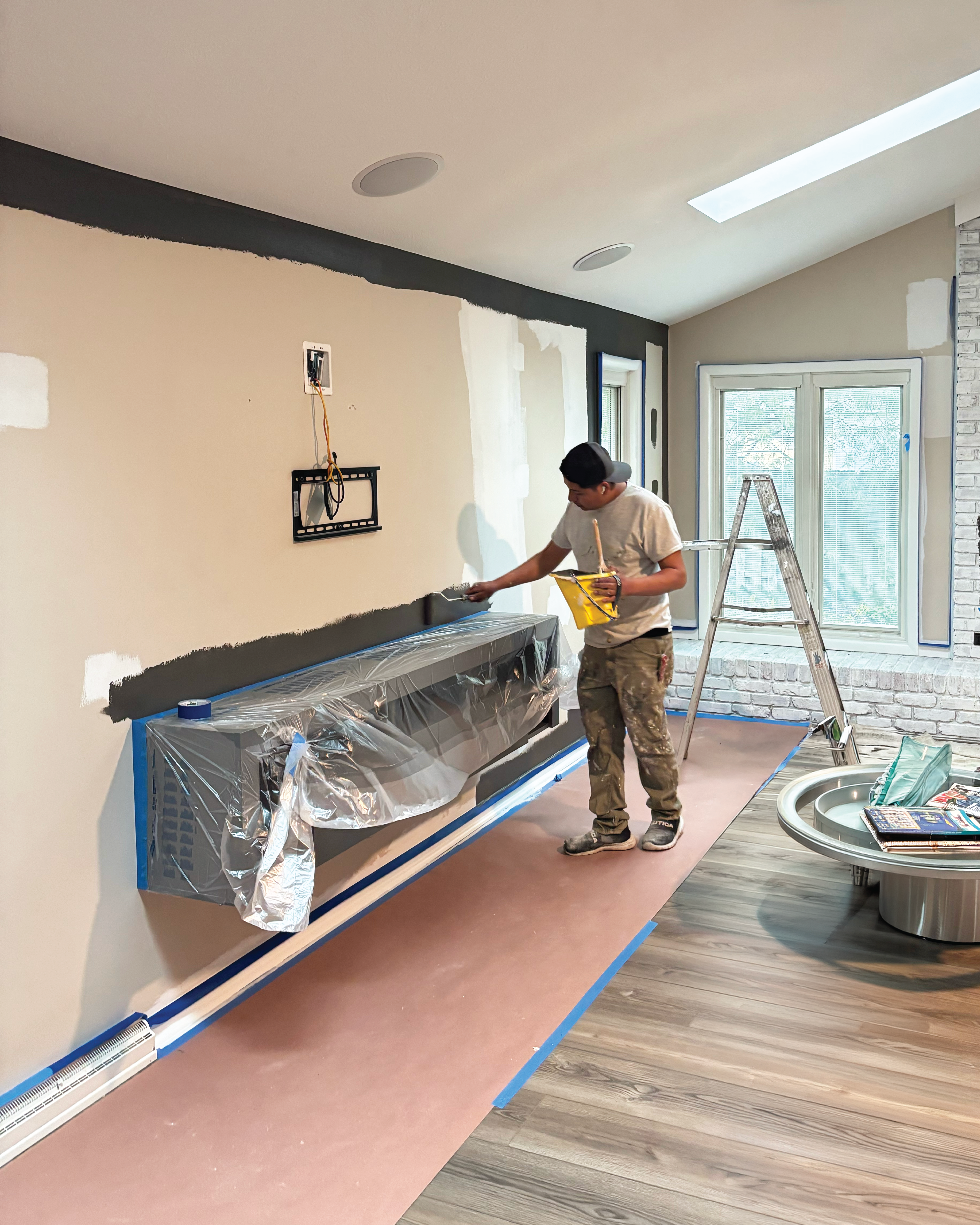 Residential home's living room getting repainted by crew member.