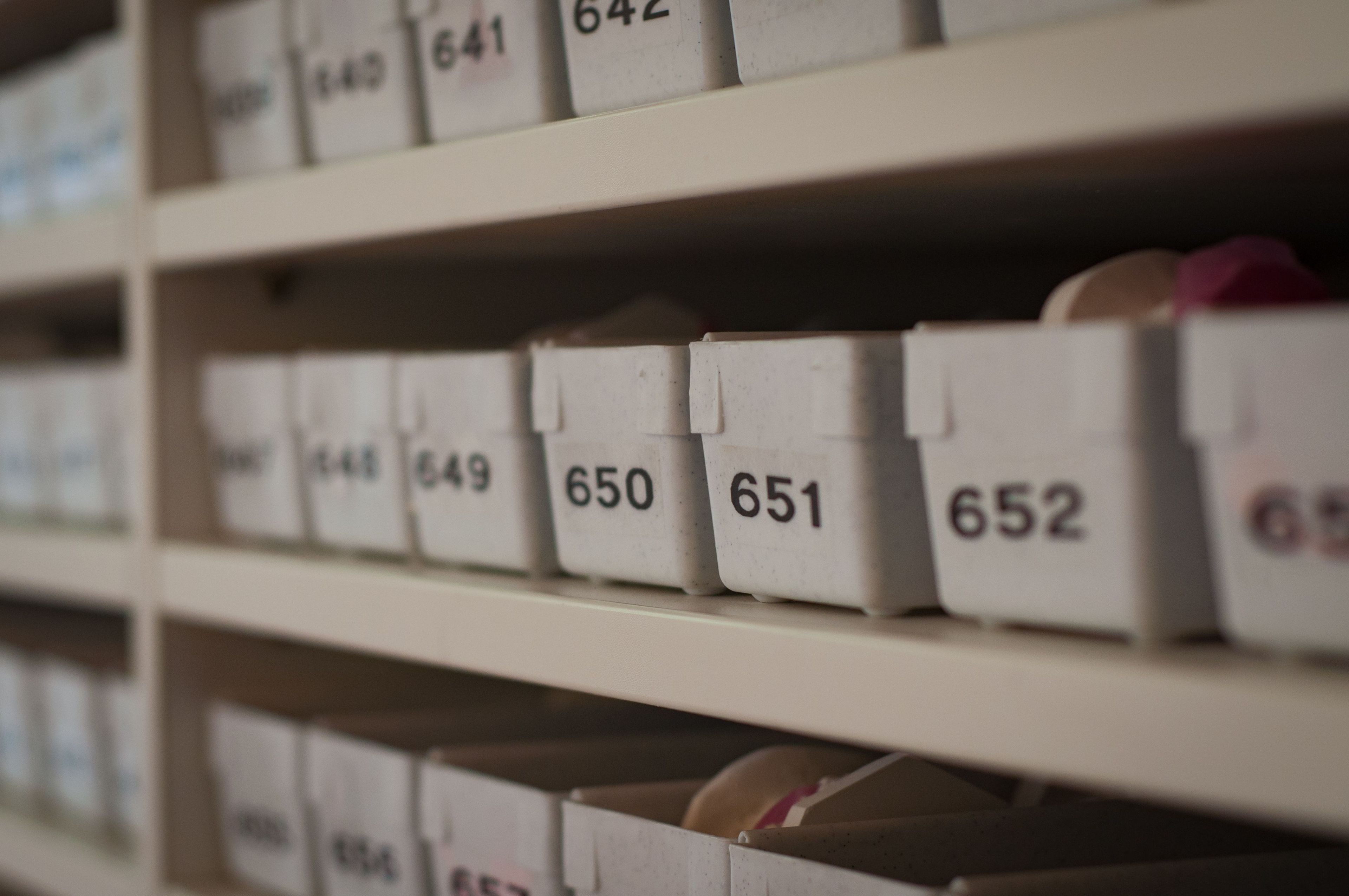 Numbered white storage bins arranged in rows on shelves