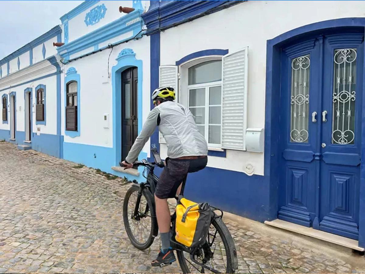 a person cycling through a charming village in the Algarve region of Portugal, known for its picturesque architecture and popular cycling routes