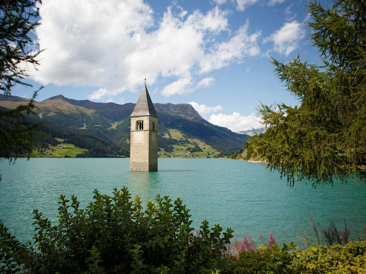 the iconic submerged bell tower in Lake Resia (Reschensee), an artificial lake in South Tyrol, Italy