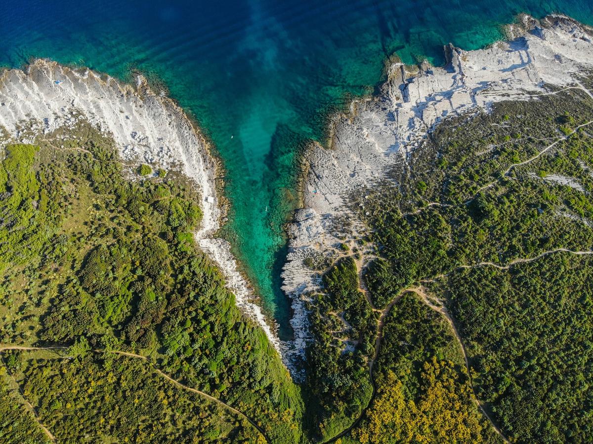 an aerial view of the rugged coastline of Cape Kamenjak, also known as the Kamenjak Peninsula or Peninsula of Premantura (Punta), located at the southernmost tip of Istria, Croatia