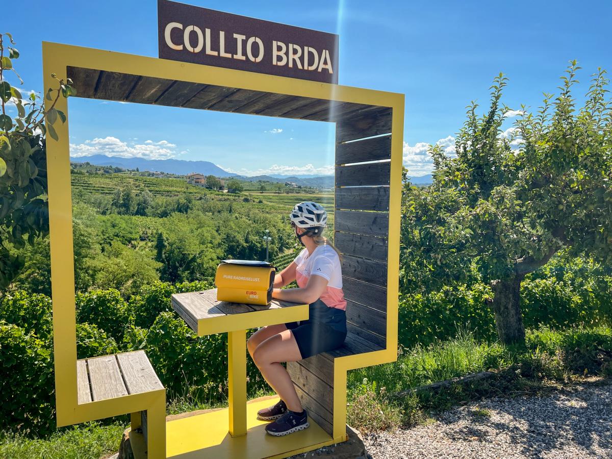 a cyclist at a scenic viewpoint in the Collio Brda region, a renowned wine-producing area straddling the border between Italy and Slovenia