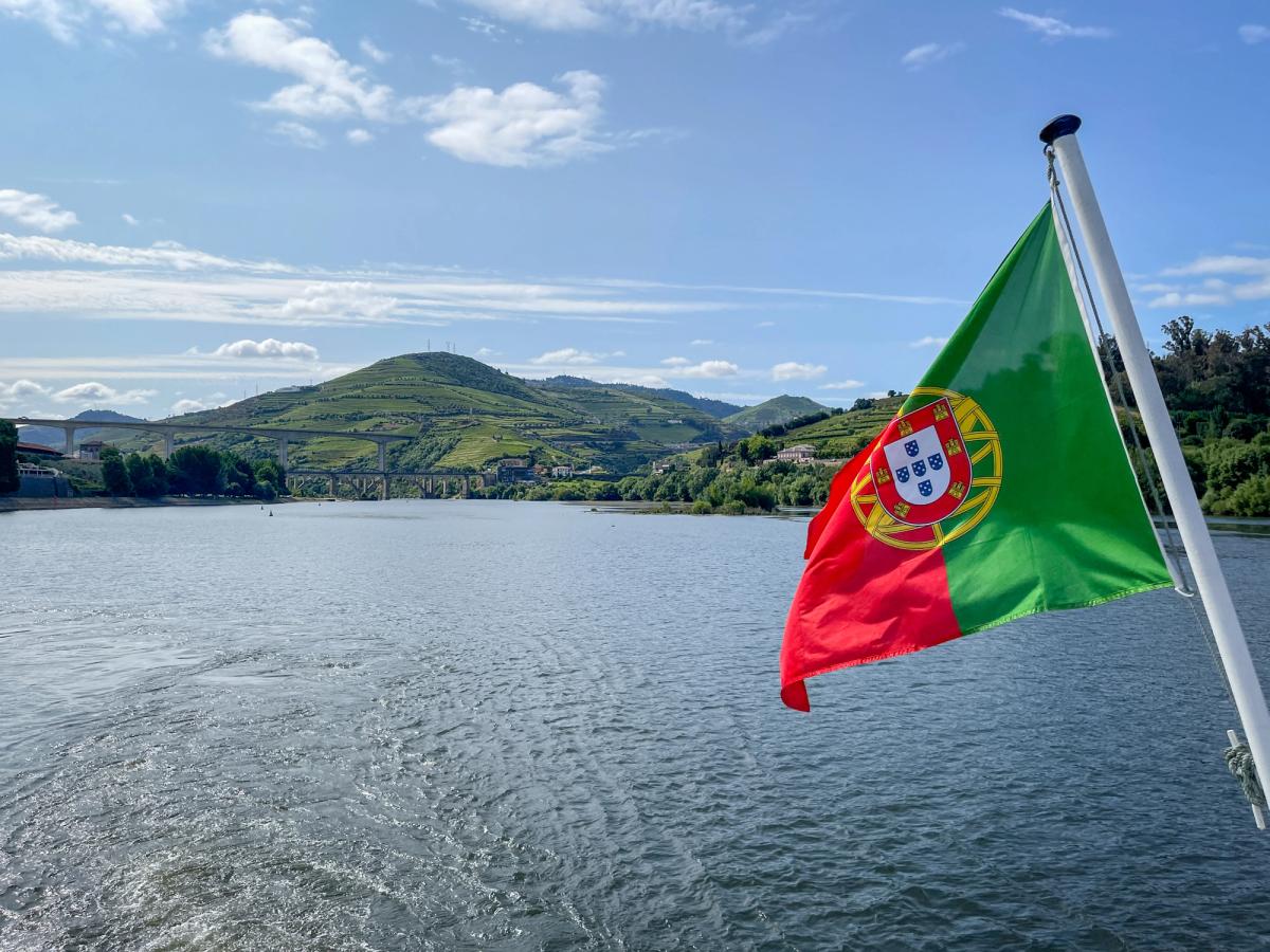 the Portuguese flag flying on a boat on the Douro River in Portugal, likely during a river cruise