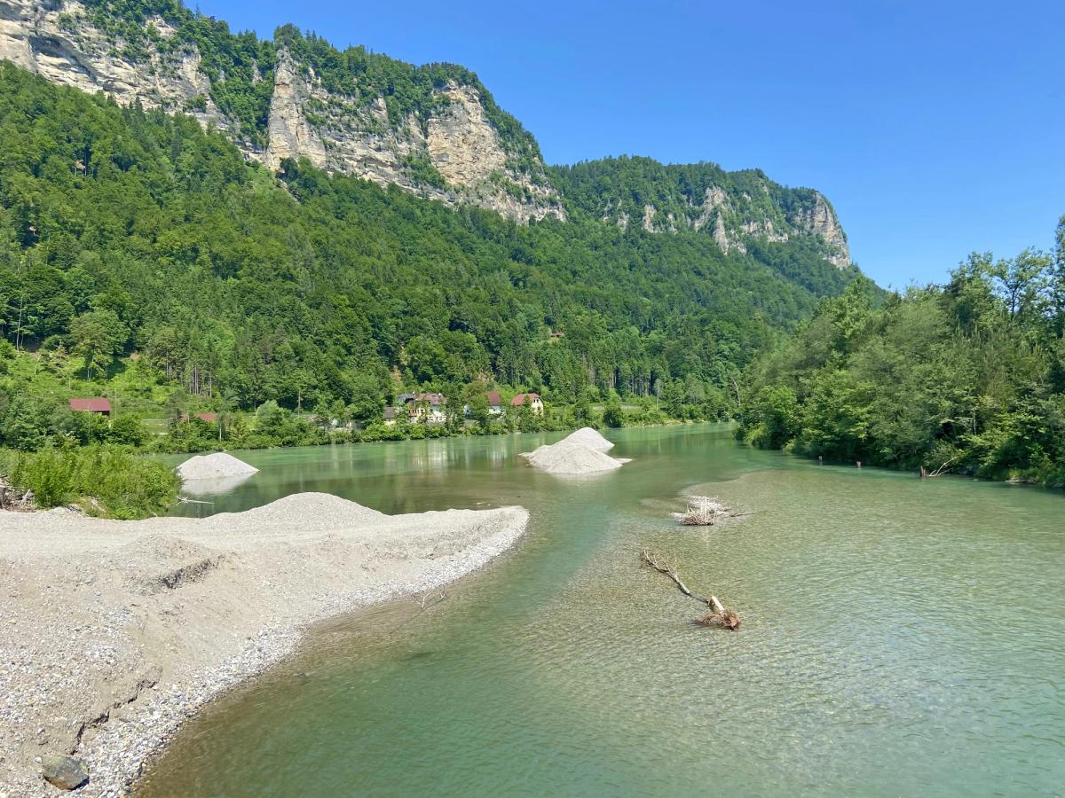 a scenic view of the Drau River (also known as Drava) in a mountainous region, likely in Carinthia, Austria, or along the Drau Cycle Path