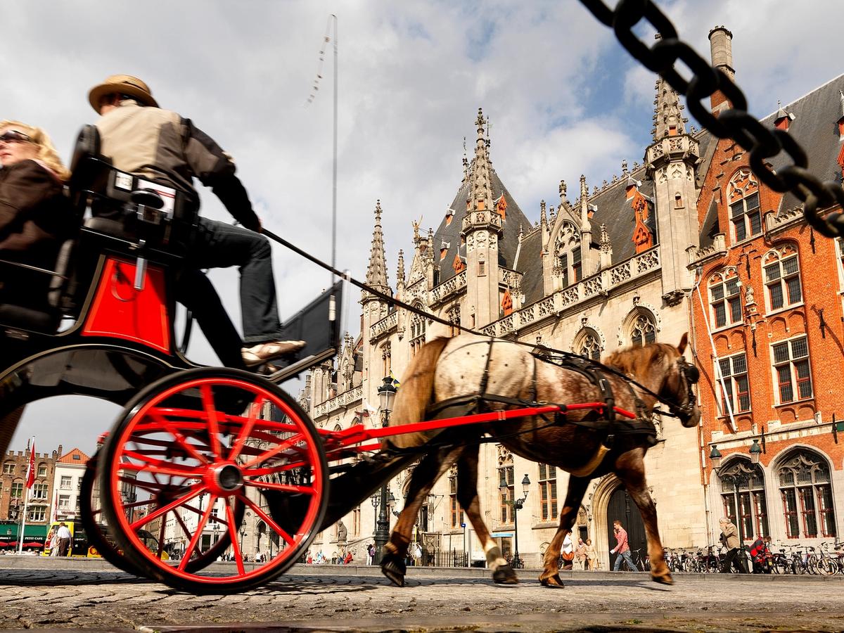 a horse-drawn carriage tour in the Markt (Market Square) of Bruges, Belgium