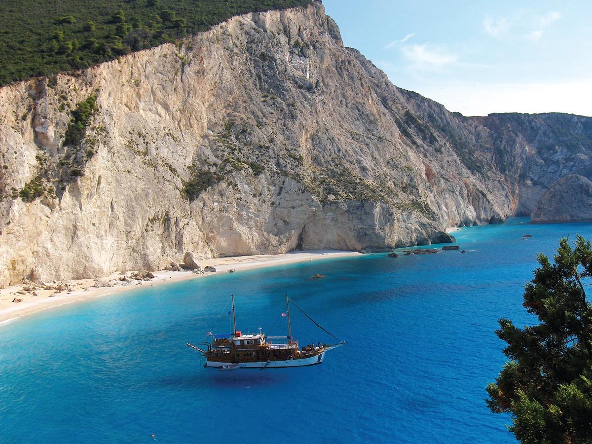 a stunning view of a beach and cliffs, typical of the Ionian Islands in Greece, specifically Porto Katsiki beach on the island of Lefkada