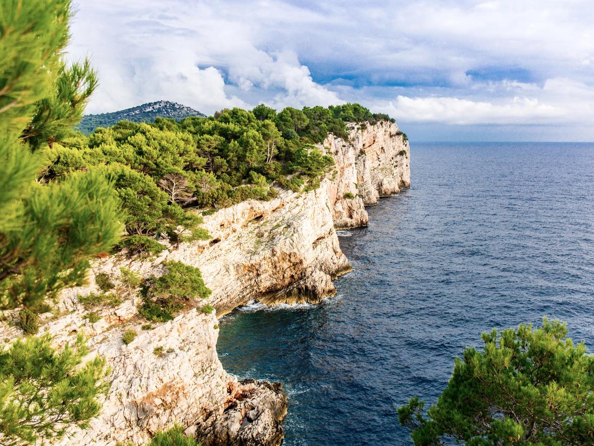 the iconic cliffs of the Dalmatian Coast in Croatia, particularly those found in national parks like Krka or Kornati, or along the coastline of islands such as Dugi Otok or Vis