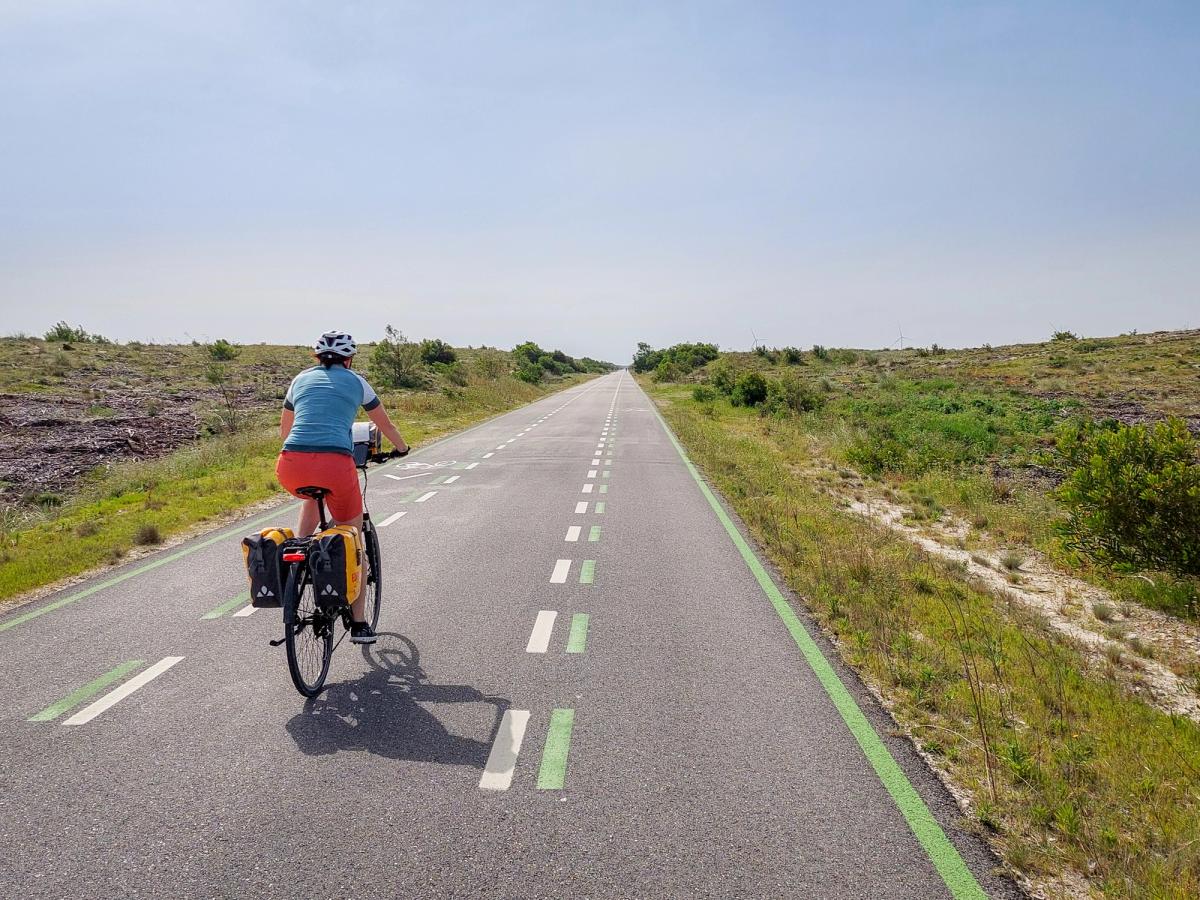 person riding a bicycle on a paved road