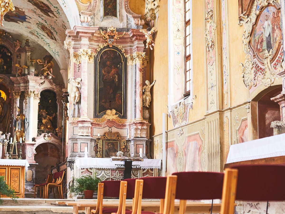 the interior of a Baroque church, with a style similar to the Benedictine monastery of Metten in Bavaria, Germany, and the Church of the Holy Name of Mary in Sladka Gora, Slovenia