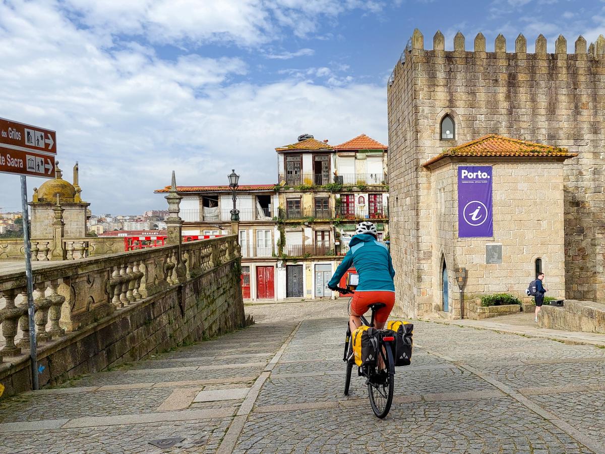 a person cycling near the Porto Cathedral (Sé do Porto) in Porto, Portugal