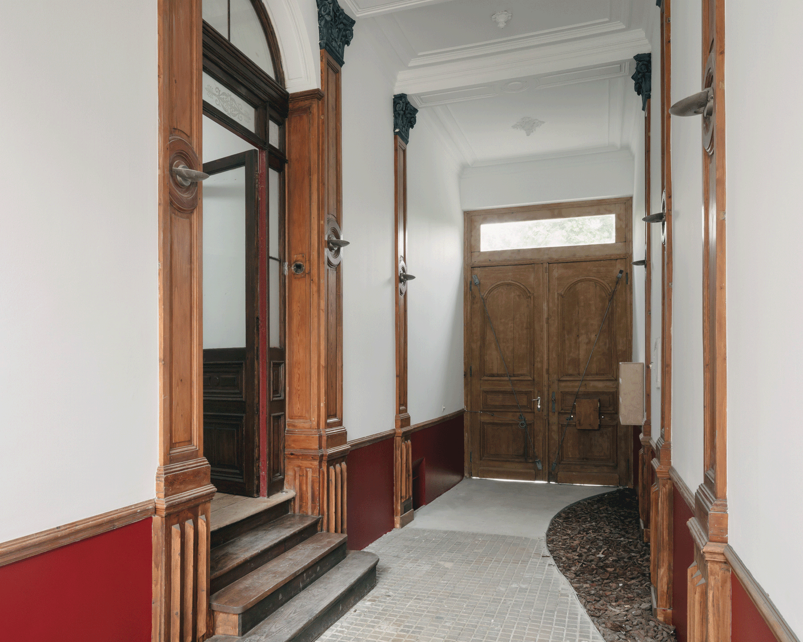 Restored corridor with carved timber door frames and terrazzo floor