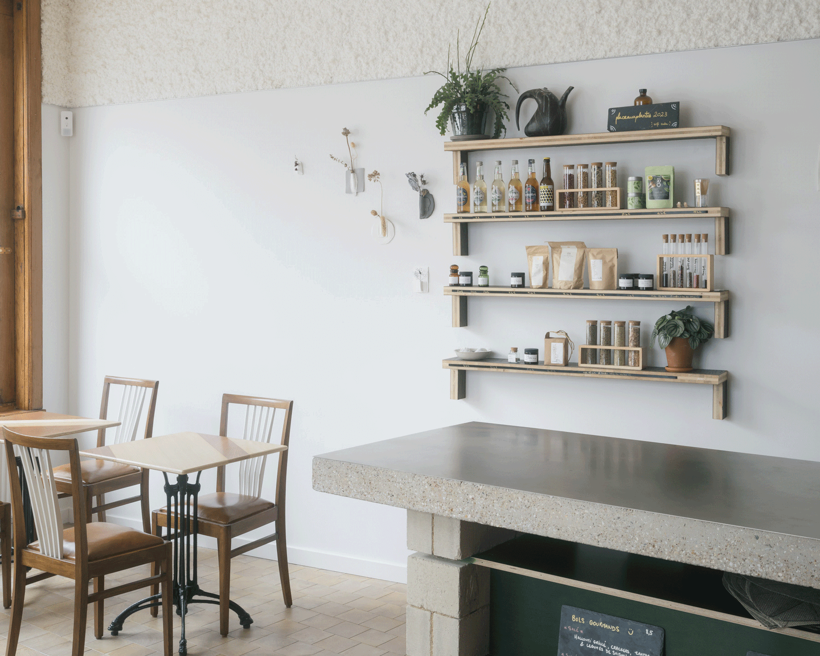 Shared table and wall shelves beside the terrazzo service counter