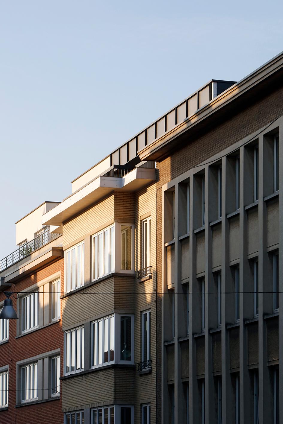 Street view of the dark rooftop extension above a brick apartment block