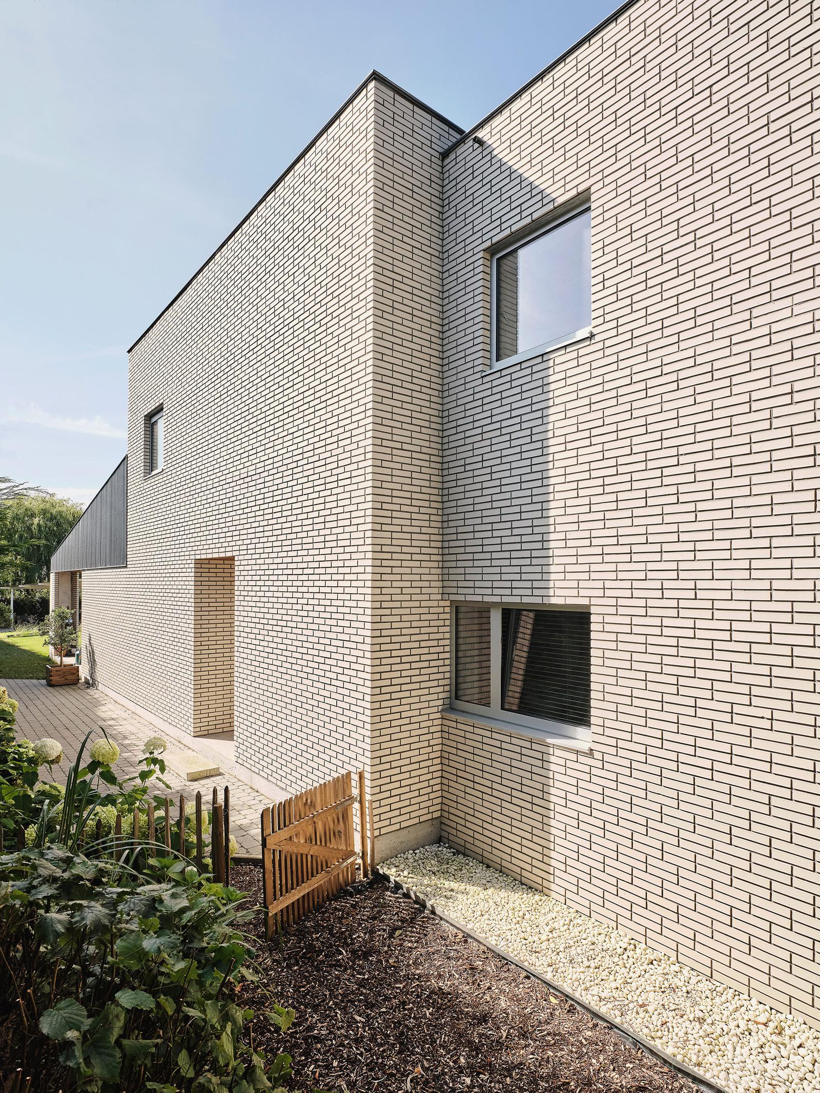 Tall pale brick side wall with scattered square openings
