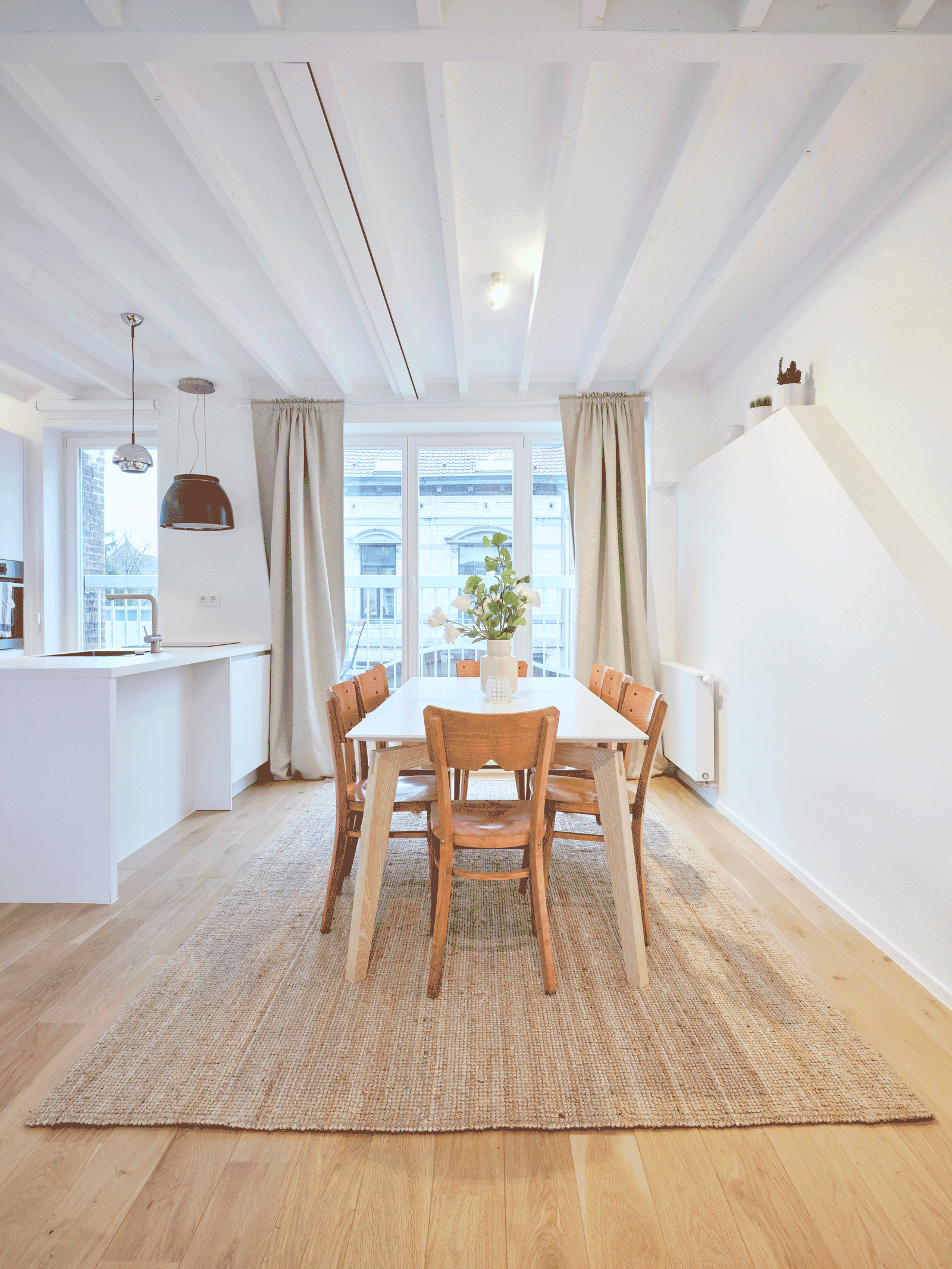 Long dining room with timber floors and tall street windows