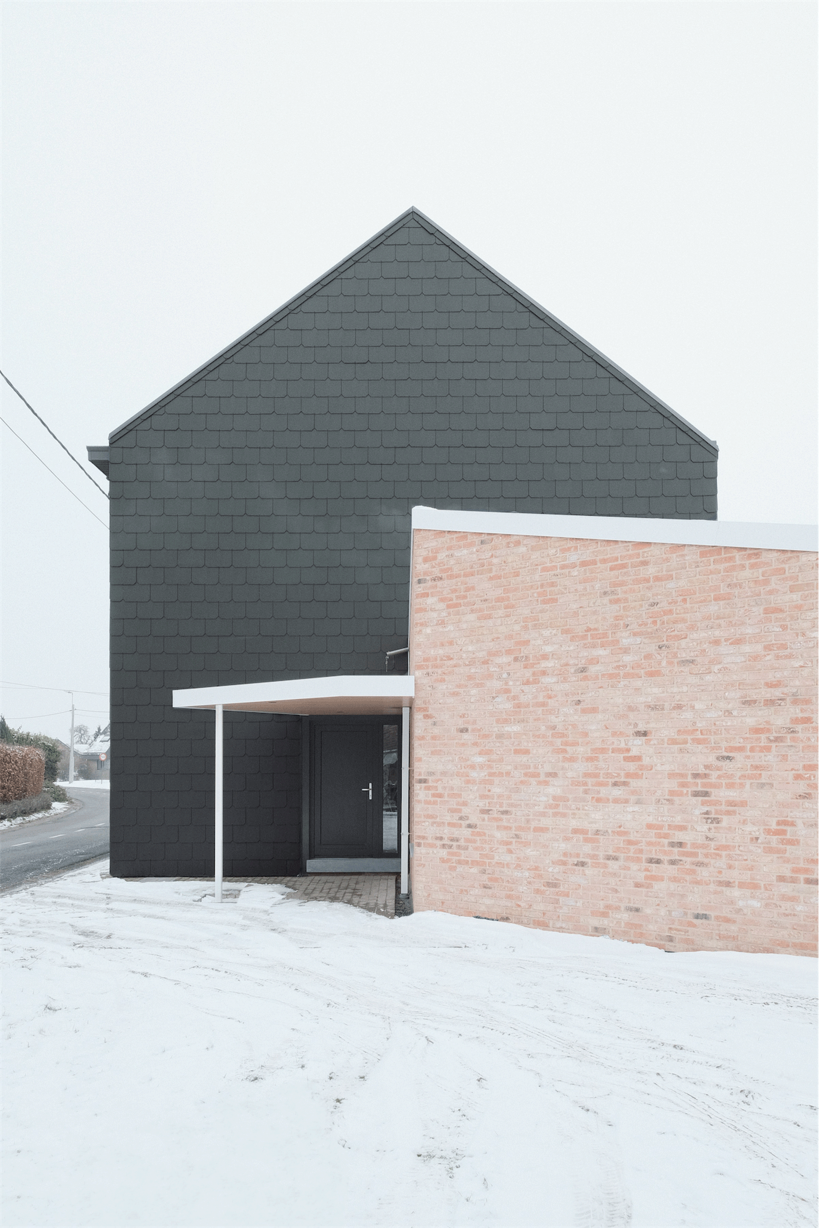 Dark gable and low brick wall framing the side entrance