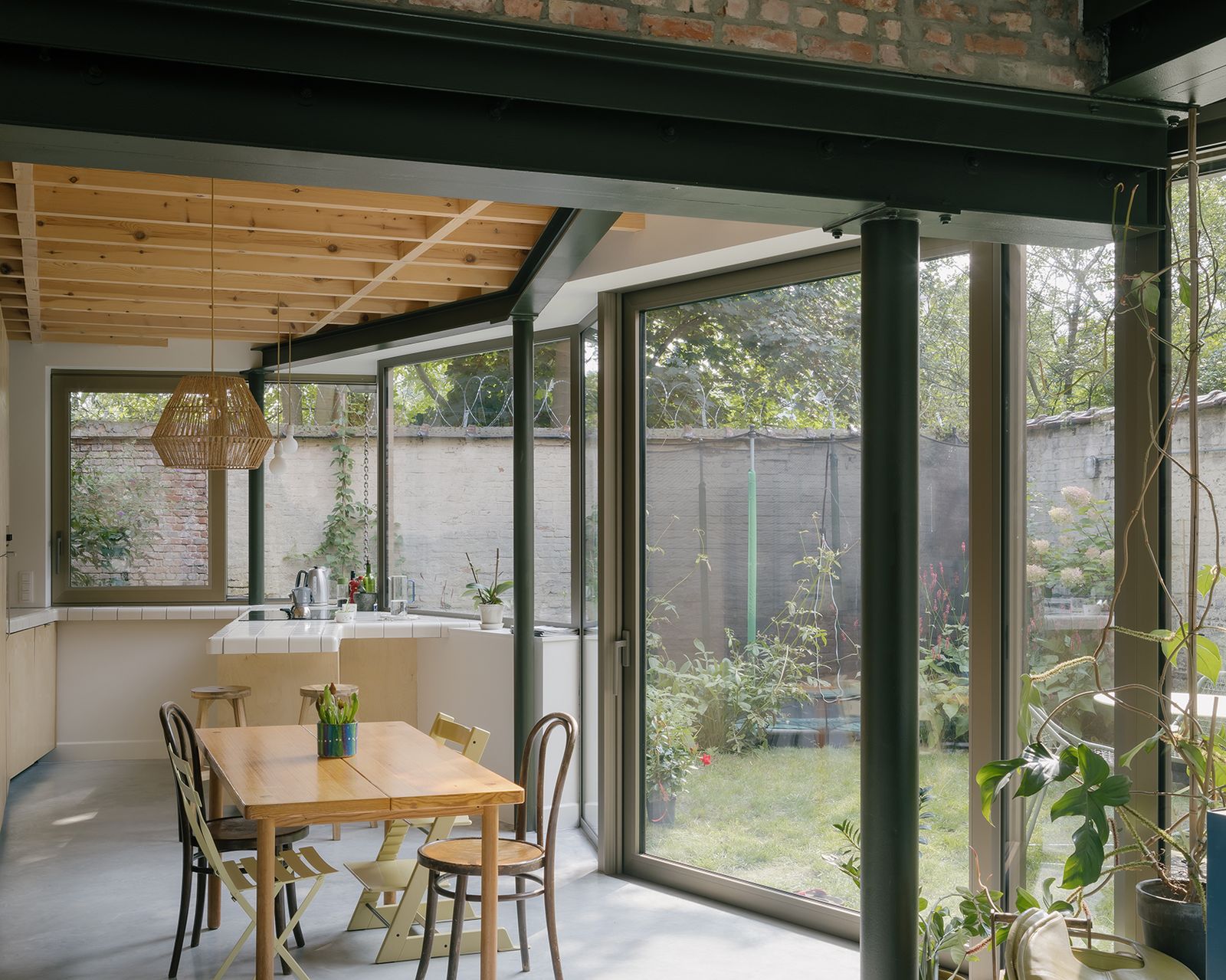 Dining room with timber ceiling and full-height garden glazing