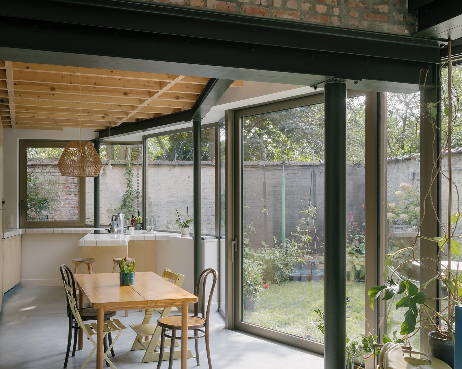 Dining room with timber ceiling and full-height garden glazing