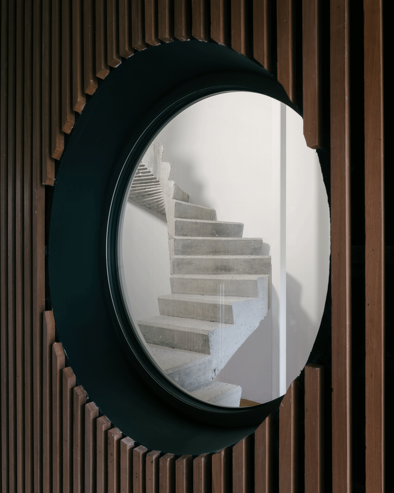 Circular window set within the vertical timber slats