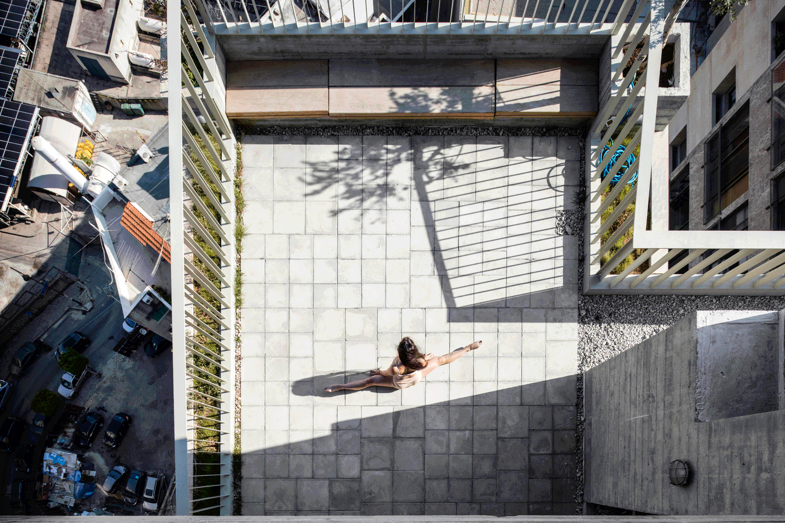 Overhead view of a square rooftop courtyard and long shadows