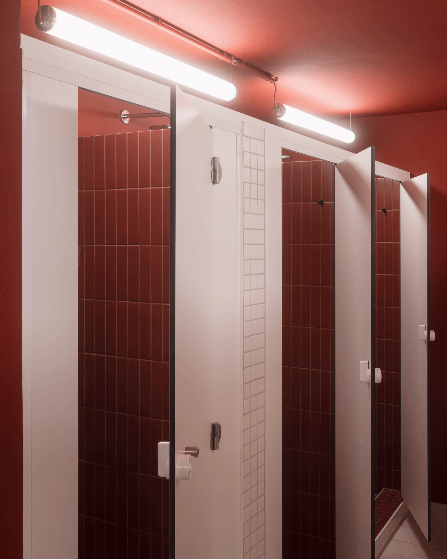 Changing cubicles lined with glossy red and white tiles