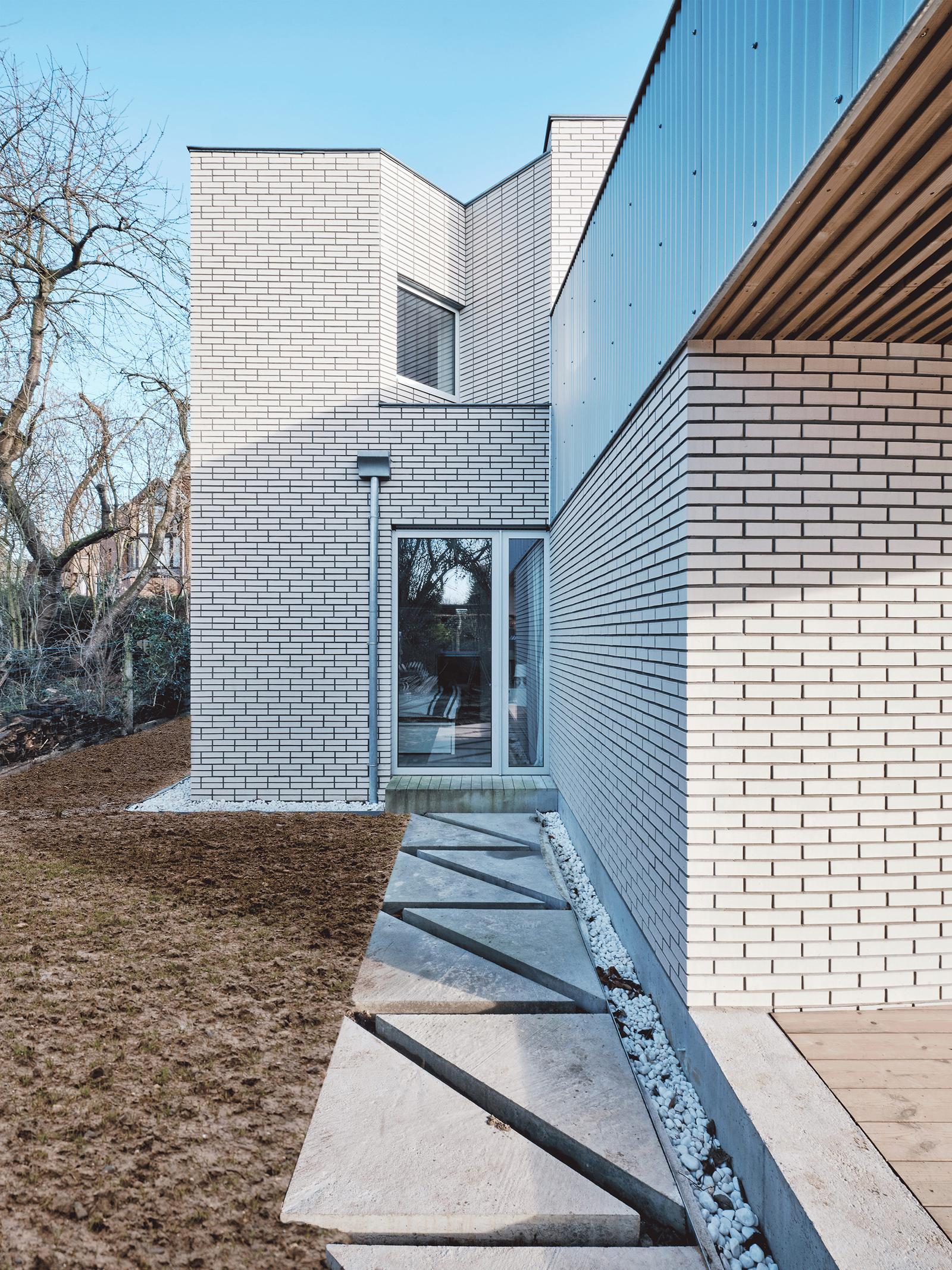 Narrow courtyard passage between two pale brick wings