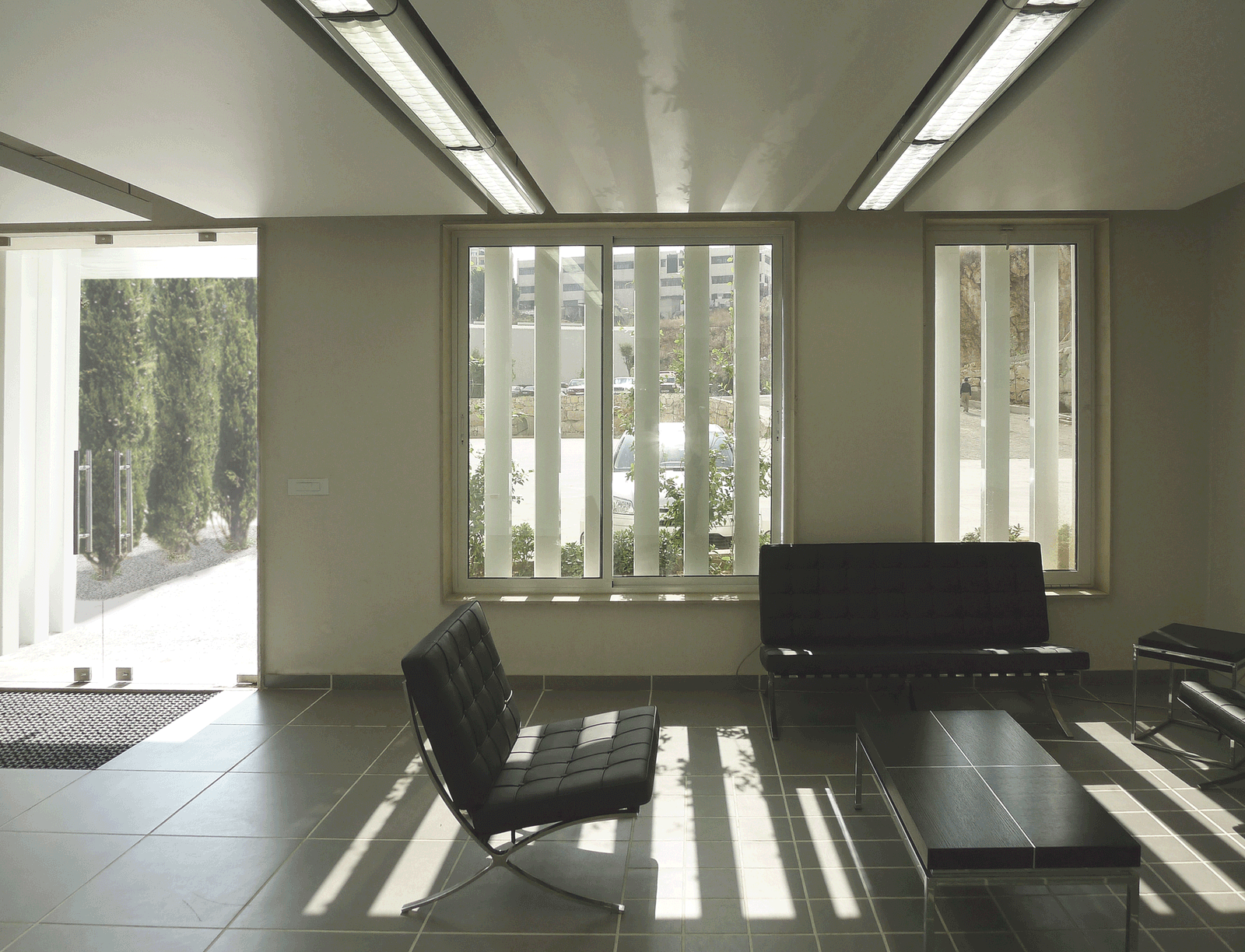 Interior lounge striped by daylight passing through vertical louvers