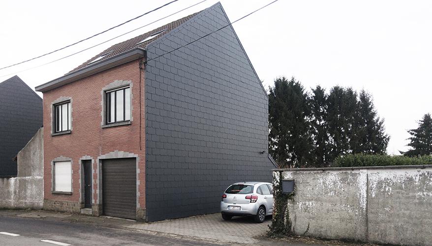 Existing brick house with one side wrapped in dark cladding