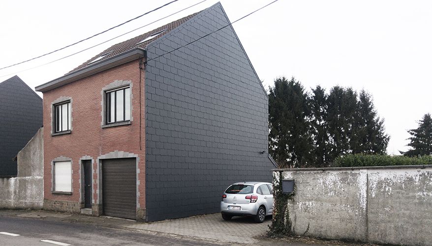Existing brick house with one side wrapped in dark cladding
