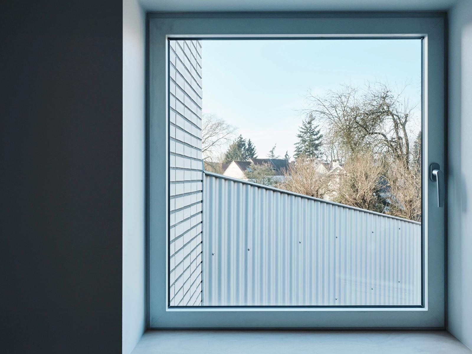Deep blue-framed window overlooking a corrugated metal roof