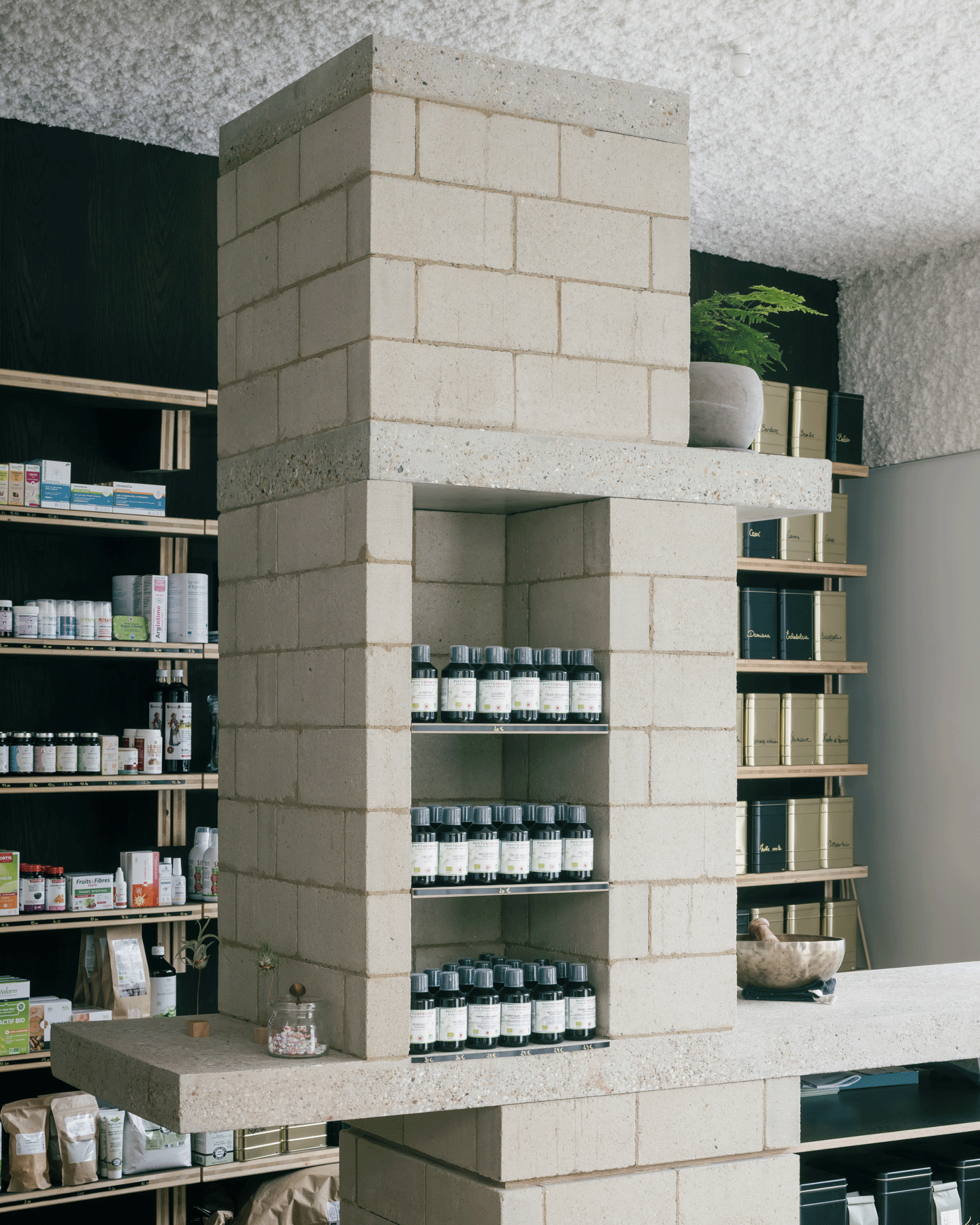 Tall terrazzo-block shelving lined with bottles and jars