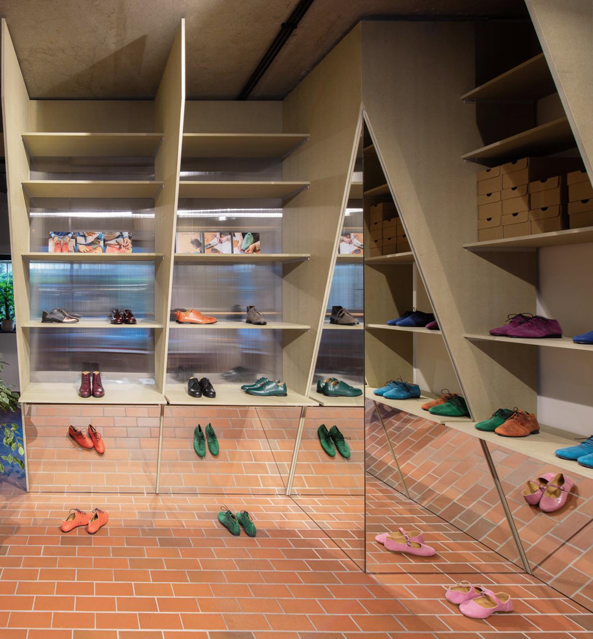 Shoe shop with mirrored surfaces and angled display shelves