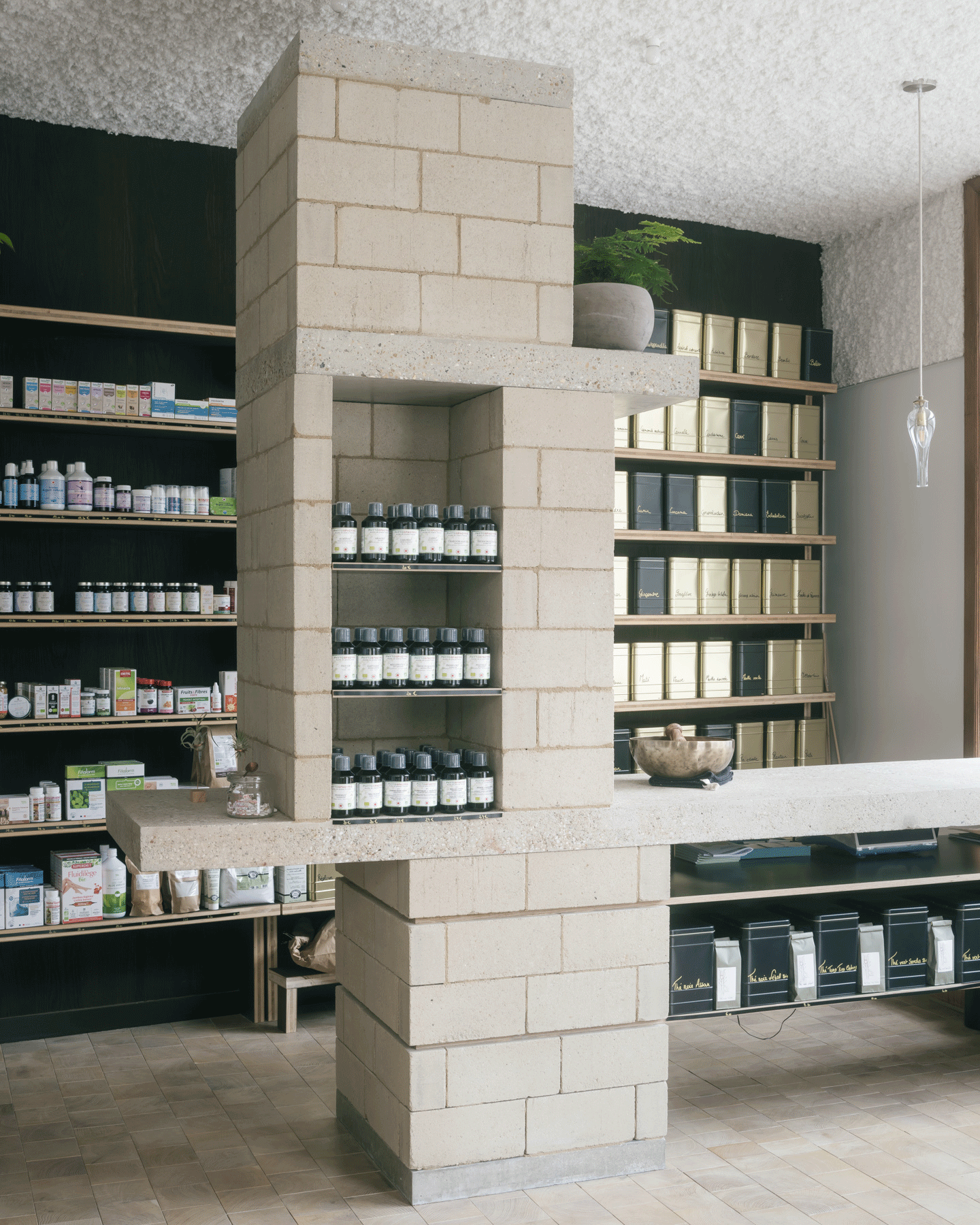 Product shelves wrapping a tall central terrazzo-block pier