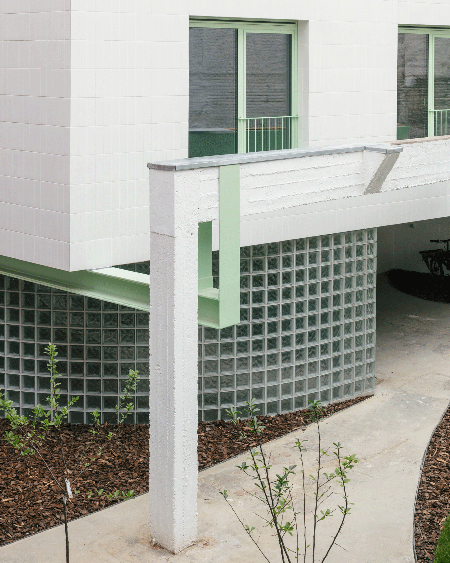 Glass-block base and white column supporting the new upper volume