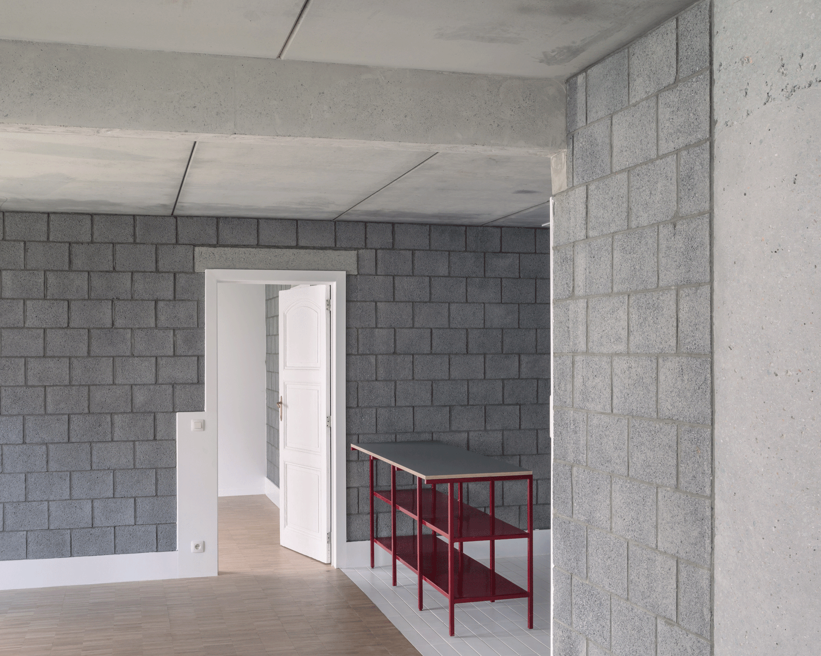 Unfinished room with concrete ceiling, block walls and red stair