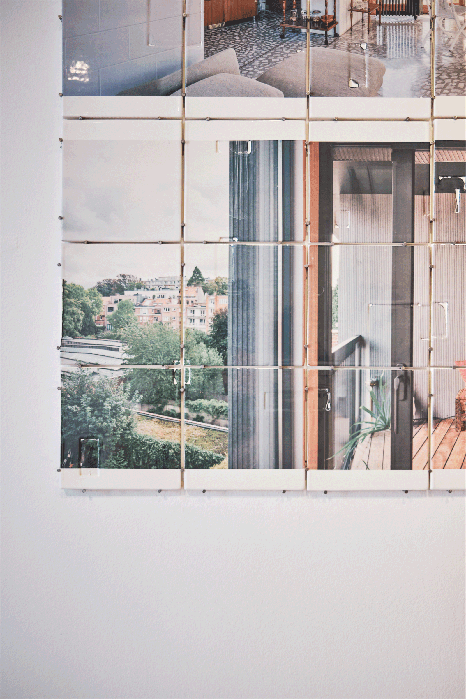 Reflective installation panel framing a view through a gallery window