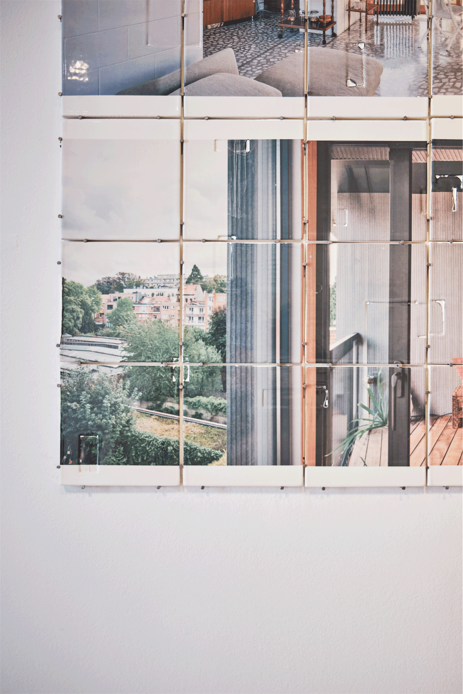 Reflective installation panel framing a view through a gallery window