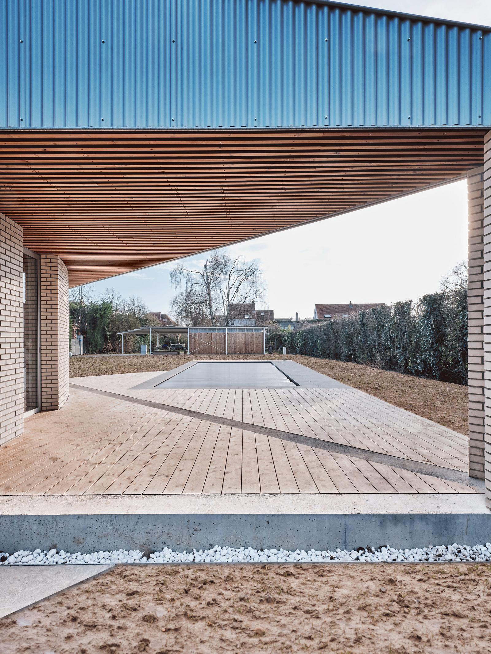 Covered timber terrace looking across the swimming pool