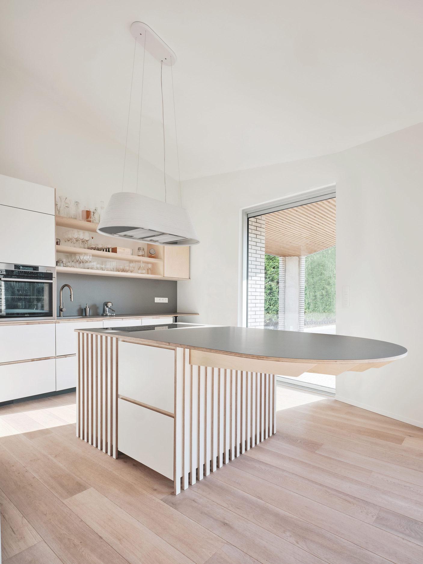 Bright kitchen with a curved island and garden window