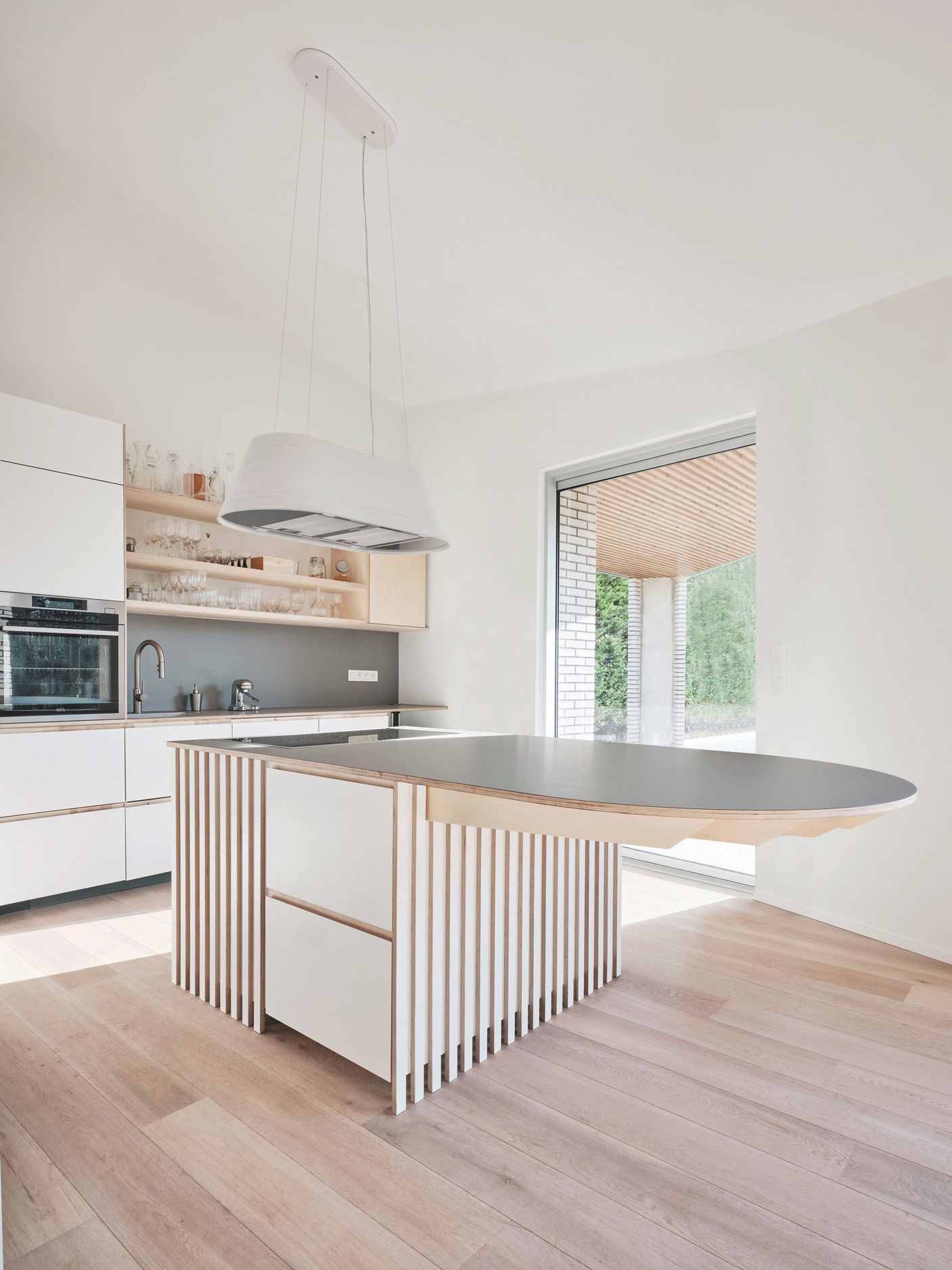 Bright kitchen with a curved island and garden window