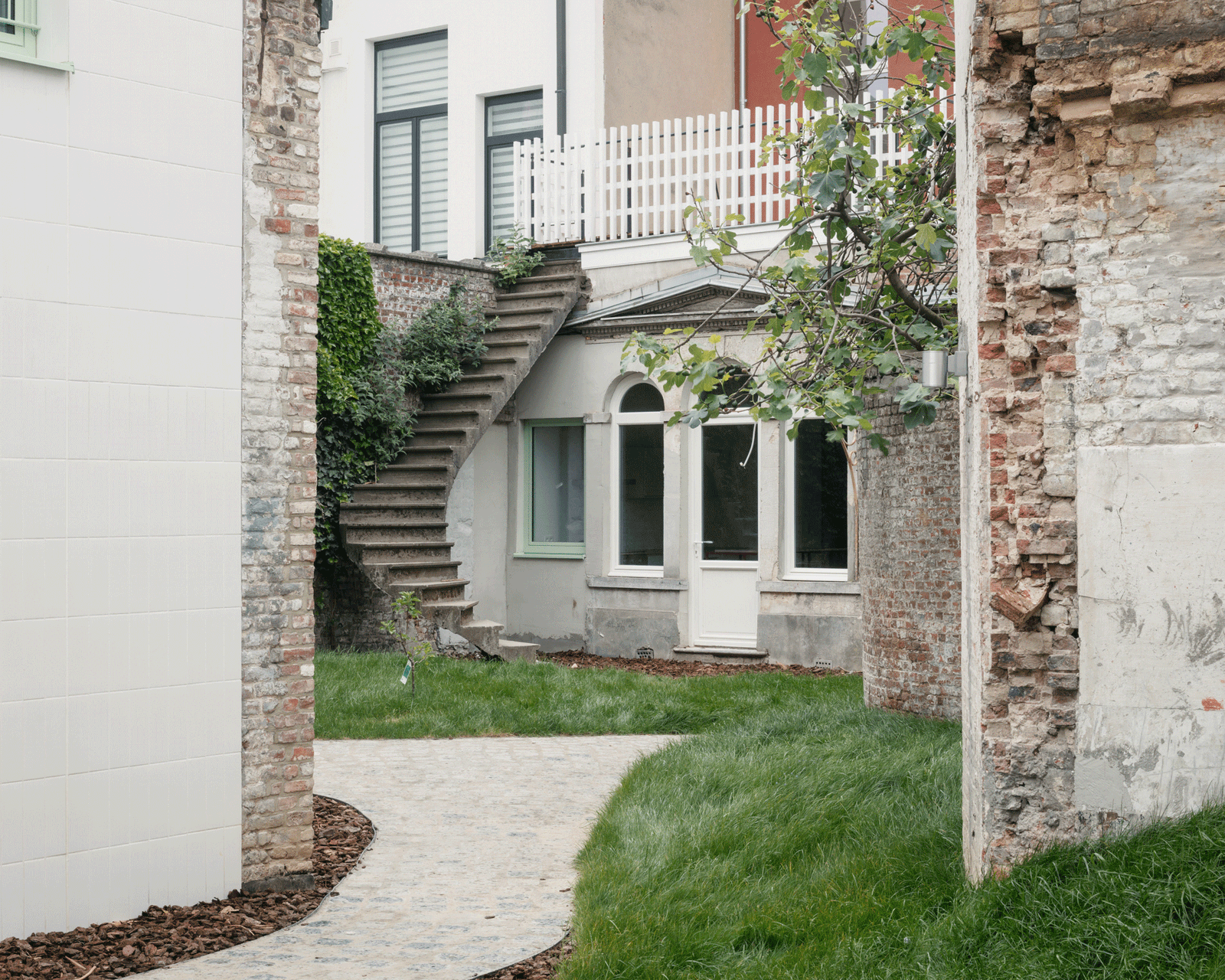 Curving garden path beside the retained historic rear façade