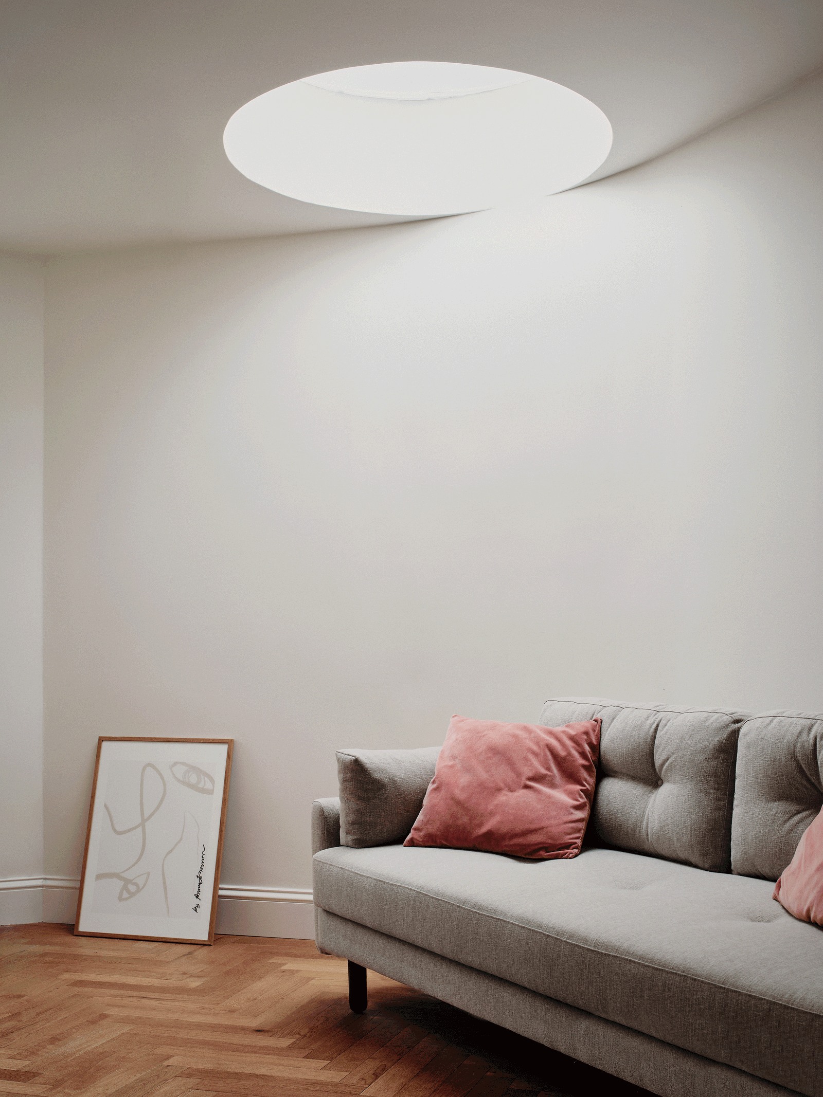 Living room lit by a large circular roof light