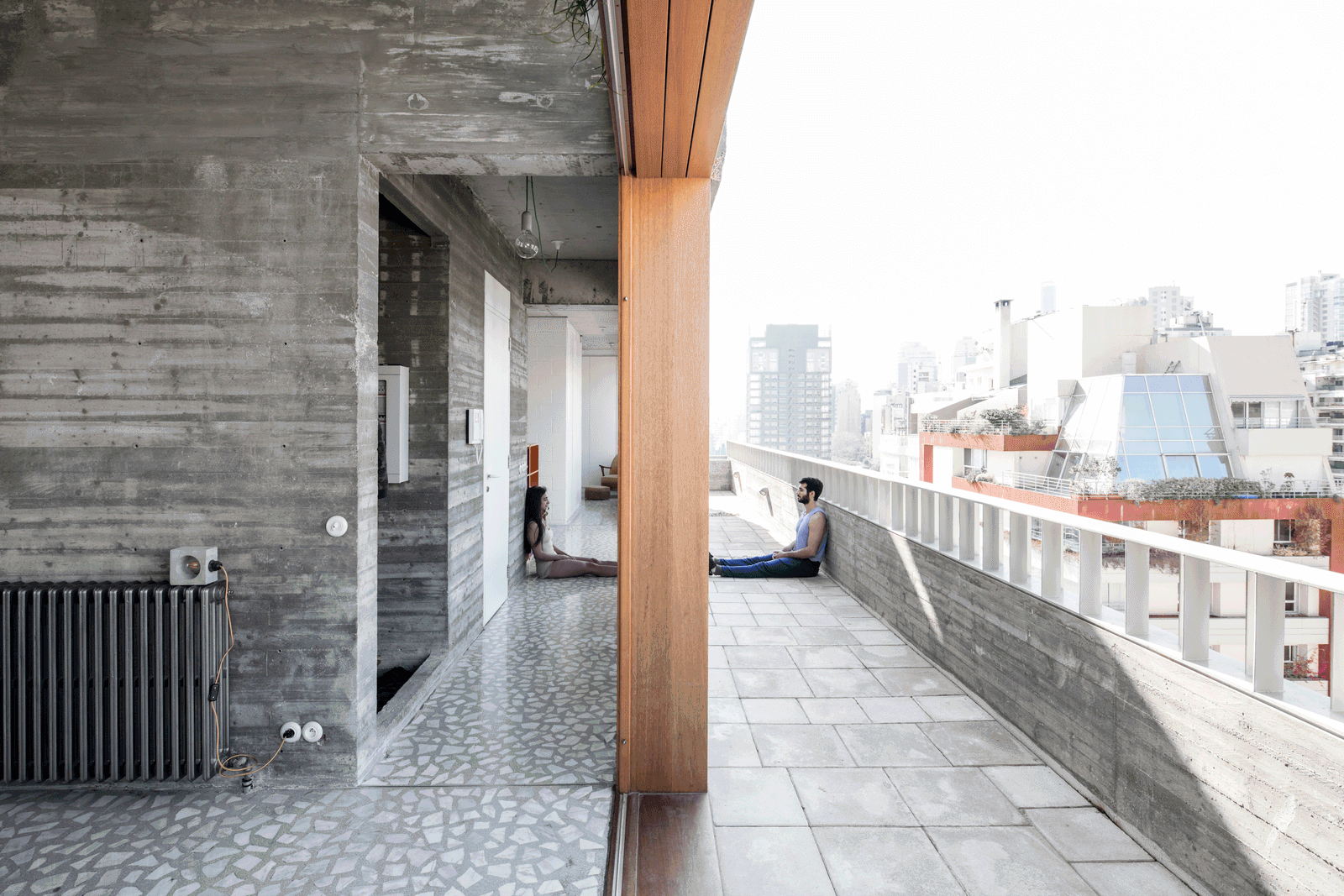 Long tiled roof terrace beside concrete walls and timber glazing
