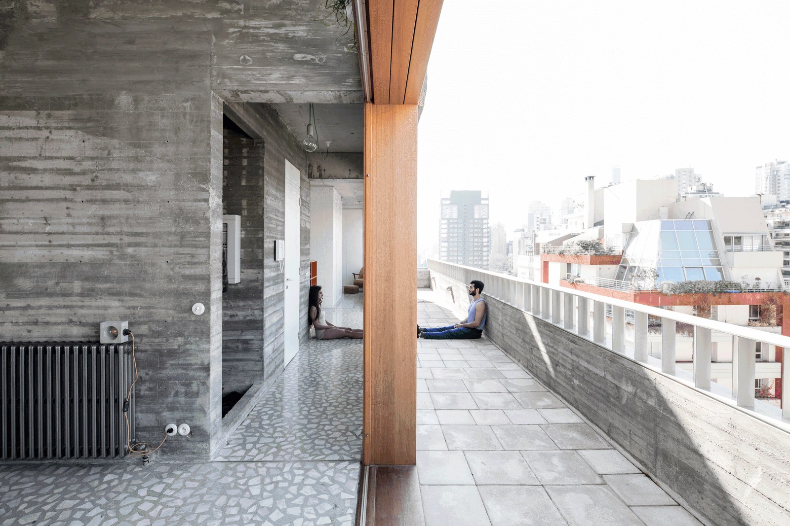 Long tiled roof terrace beside concrete walls and timber glazing