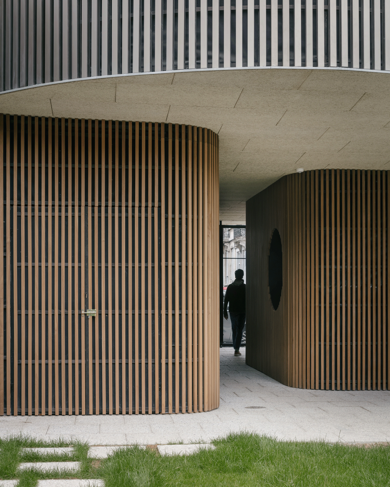 Covered passage winding between rounded timber-clad walls