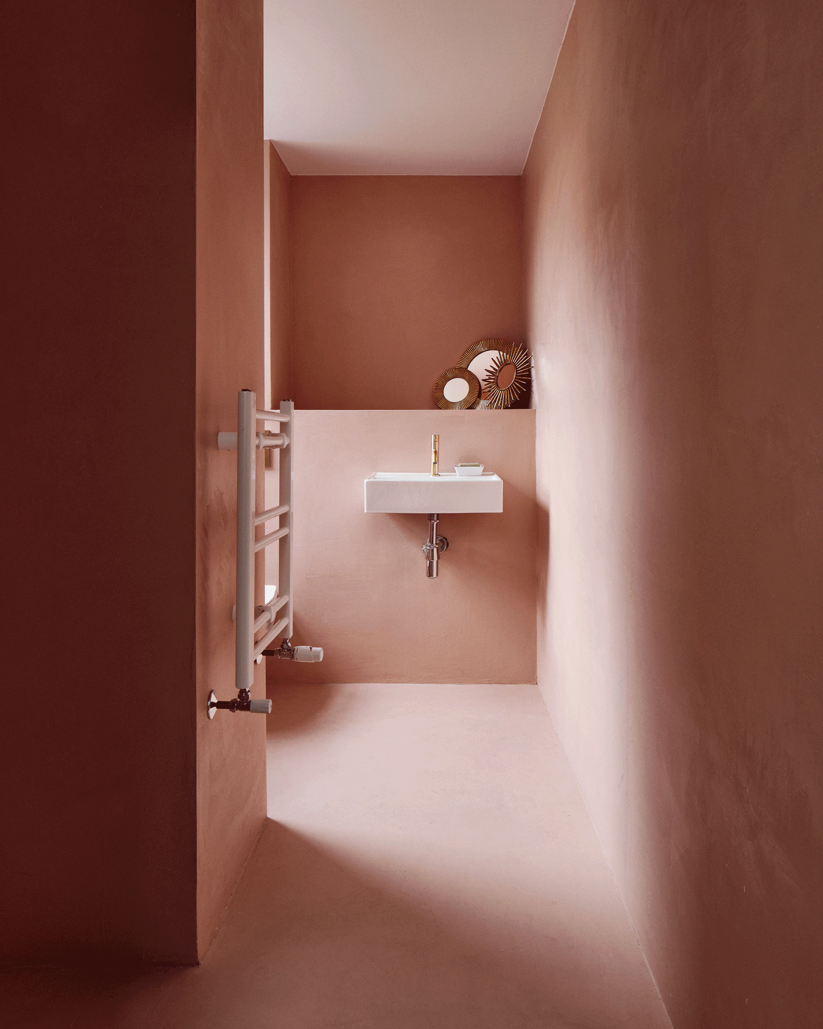Compact washroom finished in warm pink plaster