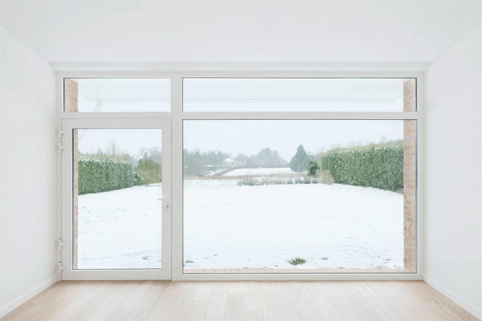 Living room with a broad glazed wall facing the snowy garden