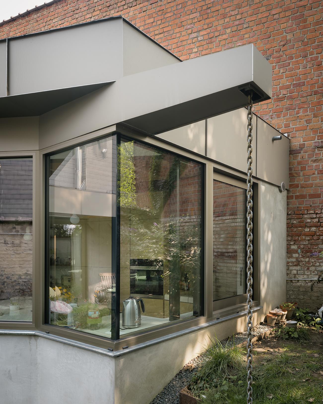 Glazed pavilion extending from the existing brick wall