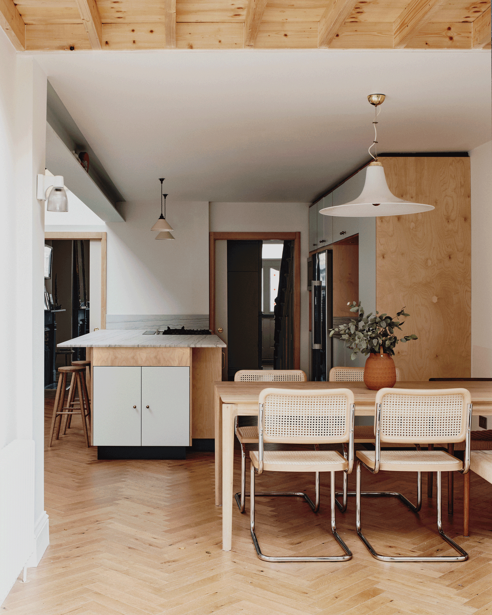 Dining table between the open kitchen and timber stair